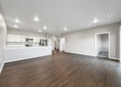 Thumbnail 25 of 51 - A spacious room with wooden flooring and white walls.