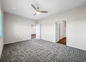 Thumbnail 37 of 51 - A room with a ceiling fan and carpeted floor.