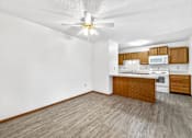 Thumbnail 2 of 53 - A kitchen with a white ceiling fan and wooden flooring.