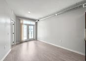 Thumbnail 52 of 59 - A spacious room with a slanted ceiling and a doorway leading to another room.
