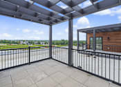 Thumbnail 47 of 77 - Private balcony with overhead pergola and city views at The Flats at West Glen Apartments, West Des Moines