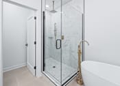 Thumbnail 52 of 77 - Luxury bathroom with glass shower and freestanding tub at The Flats at West Glen Apartments, West Des Moines