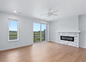 Thumbnail 57 of 77 - Spacious living room with stone fireplace and balcony access at The Flats at West Glen Apartments, Iowa, 50266