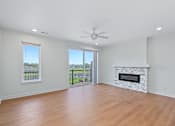 Thumbnail 55 of 77 - Open living room with stone fireplace and lake views at The Flats at West Glen Apartments, West Des Moines, IA 50266