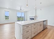 Thumbnail 61 of 77 - Open kitchen island with white quartz countertop at The Flats at West Glen Apartments, Iowa