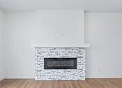 Thumbnail 62 of 77 - Contemporary living room with stacked stone fireplace at The Flats at West Glen Apartments, Iowa, 50266