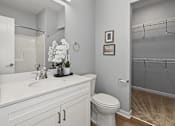 Thumbnail 48 of 53 - A white bathroom with a toilet, sink, and a mirror.