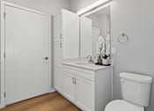 Thumbnail 46 of 53 - A white bathroom with a toilet, sink, and medicine cabinet.