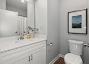 Thumbnail 45 of 53 - A white toilet sits next to a white sink in a bathroom.