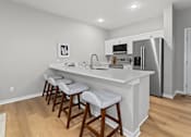 Thumbnail 2 of 53 - A kitchen with white countertops and a refrigerator.