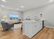 Thumbnail 4 of 53 - A modern kitchen with white cabinets and a wooden floor.