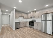 Thumbnail 16 of 53 - A kitchen with wooden floors and stainless steel appliances.