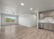 Thumbnail 7 of 53 - A kitchen area with wooden floors and a window showing a view of a field.