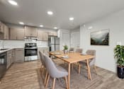 Thumbnail 2 of 53 - A modern kitchen with a dining table set for four.
