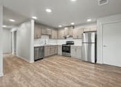 Thumbnail 5 of 53 - A kitchen with wooden floors and stainless steel appliances.