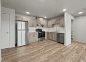 Thumbnail 27 of 53 - A kitchen with wooden floors and white walls.