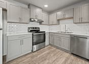 Thumbnail 26 of 53 - A modern kitchen with stainless steel appliances and wooden flooring.