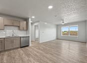 Thumbnail 29 of 53 - A kitchen with wooden floors and a window showing a beach scene.