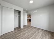 Thumbnail 19 of 53 - A room with a white door and a wooden floor.