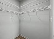 Thumbnail 15 of 53 - Empty white closet with shelves and hooks.