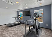 Thumbnail 47 of 53 - A room with a treadmill and a stationary bike.
