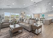 Thumbnail 44 of 53 - A living room with a grey sofa, a coffee table, and a ceiling fan.