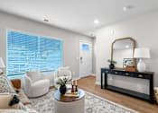 Thumbnail 4 of 90 - A living room with a white chair, a black coffee table, and a large mirror.