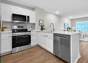 Thumbnail 79 of 90 - A modern kitchen with white cabinets and stainless steel appliances.