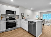 Thumbnail 74 of 90 - A modern kitchen with white cabinets and stainless steel appliances.