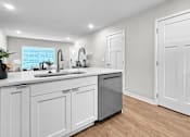 Thumbnail 76 of 90 - A modern kitchen with white cabinets and a wooden floor.