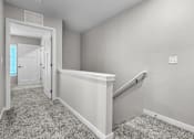 Thumbnail 77 of 90 - A room with a carpeted floor and a staircase.