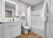 Thumbnail 6 of 90 - A white bathroom with a toilet, sink, and bathtub.
