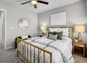 Thumbnail 75 of 90 - A bedroom with a bed, nightstand, and a ceiling fan.