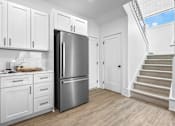 Thumbnail 23 of 36 - A kitchen with white cabinets and a stainless steel refrigerator.