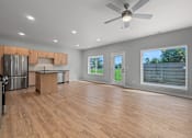 Thumbnail 1 of 34 - A spacious kitchen with wooden floors and a ceiling fan.