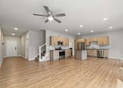 Thumbnail 9 of 34 - A spacious kitchen and living room with wooden floors and modern appliances.