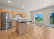 Thumbnail 6 of 34 - A kitchen with wooden floors and a large island.
