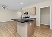 Thumbnail 5 of 34 - A kitchen with a black countertop and wooden cabinets.