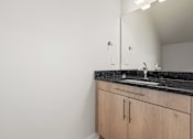 Thumbnail 23 of 34 - A bathroom with a sink and a mirror.