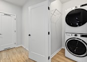 Thumbnail 20 of 34 - A white laundry room with a washer and dryer.