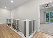 Thumbnail 25 of 34 - A room with a white railing and wooden flooring.