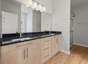 Thumbnail 21 of 34 - A bathroom with a sink, mirror, and wooden cabinets.