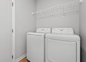 Thumbnail 30 of 53 - Two white front loading washing machines in a laundry room.