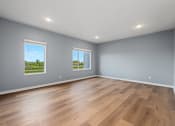 Thumbnail 14 of 53 - A room with wooden floors and two windows.