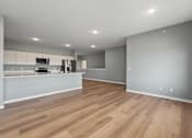 Thumbnail 16 of 53 - A kitchen with wooden floors and white walls.