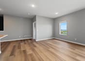 Thumbnail 18 of 53 - A room with wooden flooring and a window showing a green landscape.