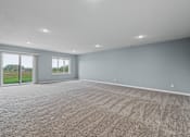 Thumbnail 13 of 53 - A large empty room with carpeted floor and two windows.