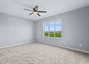 Thumbnail 25 of 53 - A room with a ceiling fan and a window showing a view of the outdoors.