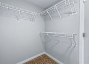 Thumbnail 29 of 53 - A white closet with two shelves and a carpeted floor.