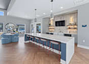 Thumbnail 10 of 53 - A modern kitchen with a bar area and a television mounted on the wall.